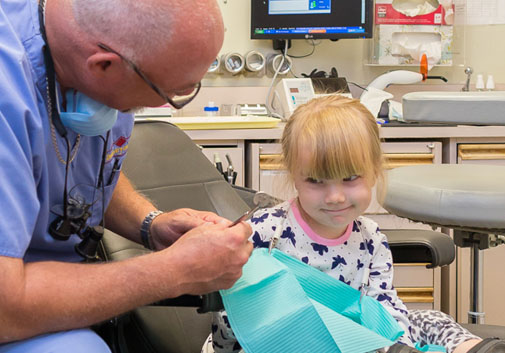 Dr. Evans explaining dental procedure to a child